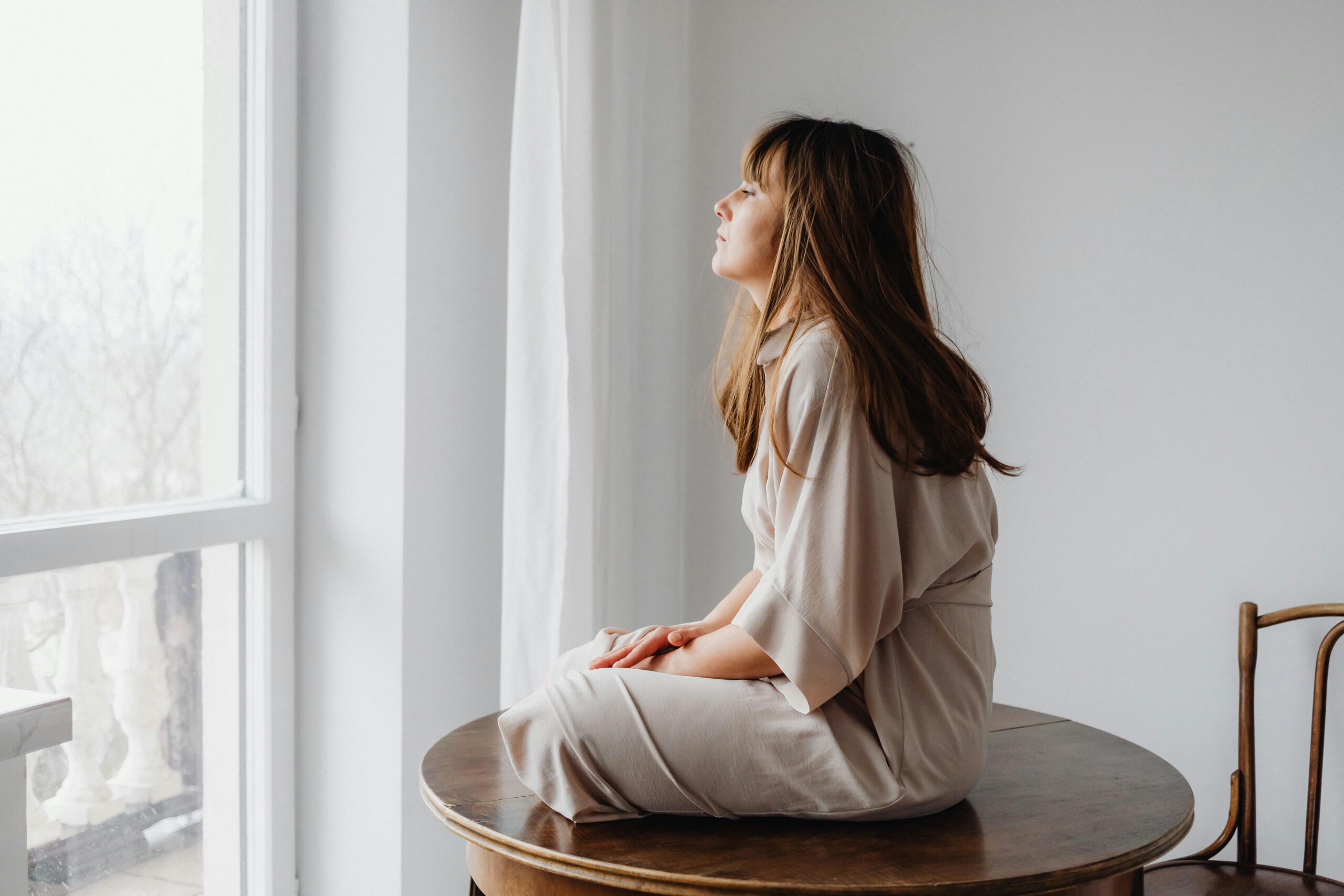 person sitting quietly by window regulating nervous system