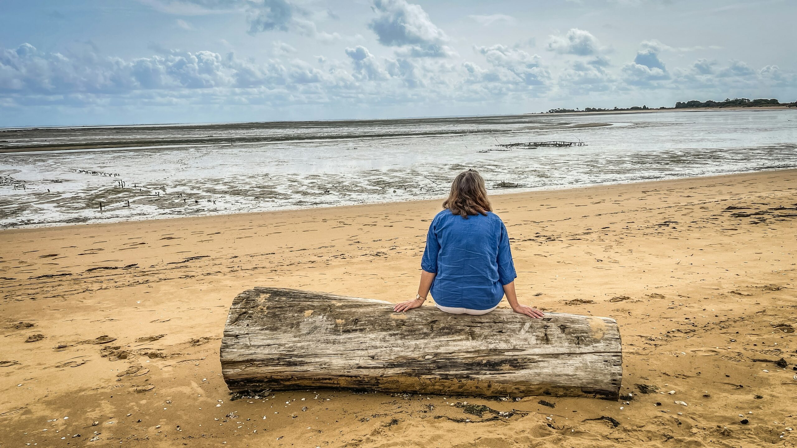 Person sitting alone on a beach after a stressful season
